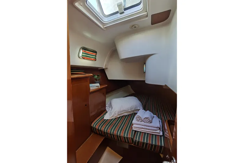  Yacht Photos Pics Cozy cabin interior of 1997 Beneteau Oceanis 461 sailboat with striped bedding.