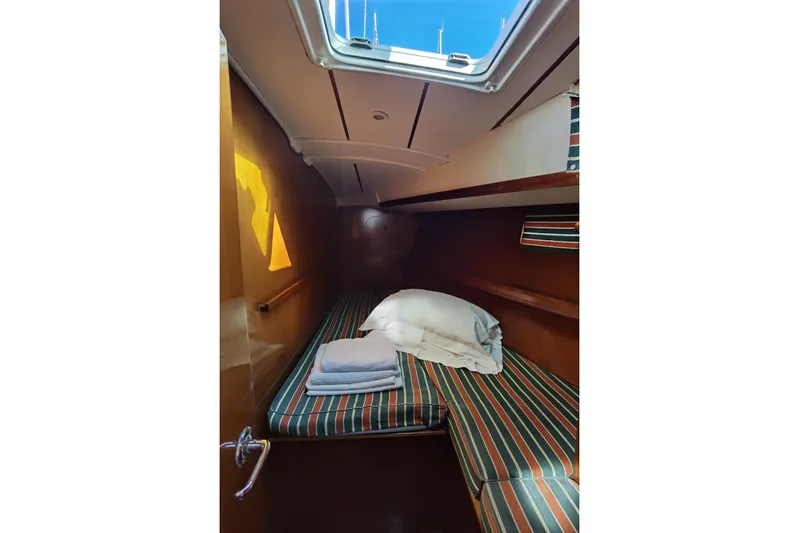  Yacht Photos Pics Cozy cabin interior of 1997 Beneteau Oceanis 461 sailboat with striped bedding.