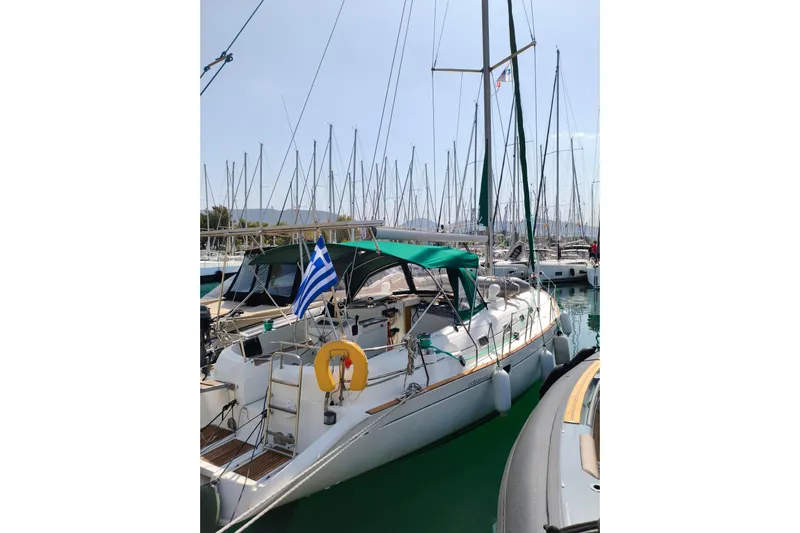  Yacht Photos Pics 1997 Beneteau Oceanis 461 sailboat docked with Greek flag, marina background.
