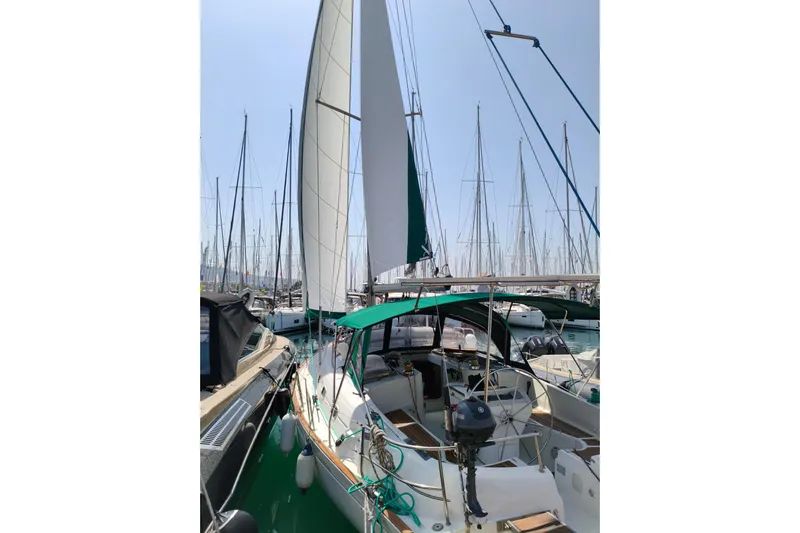  Yacht Photos Pics 1997 Beneteau Oceanis 461 sailboat docked in a marina, featuring green canopy and sails.