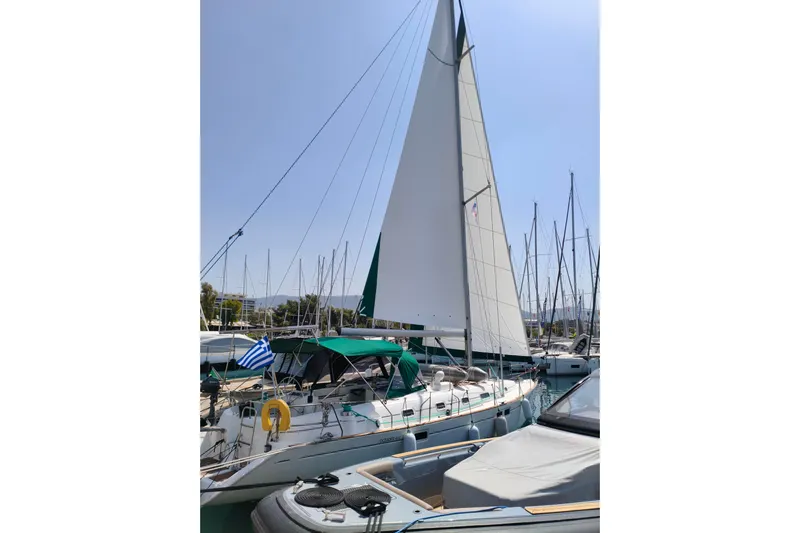  Yacht Photos Pics 1997 Beneteau Oceanis 461 sailboat docked with raised sails and Greek flag.