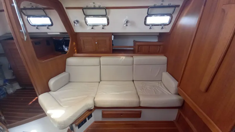 Sunny Girl Yacht Photos Pics Interior of 2004 Island Packet 370 sailboat with beige seating and wooden accents.