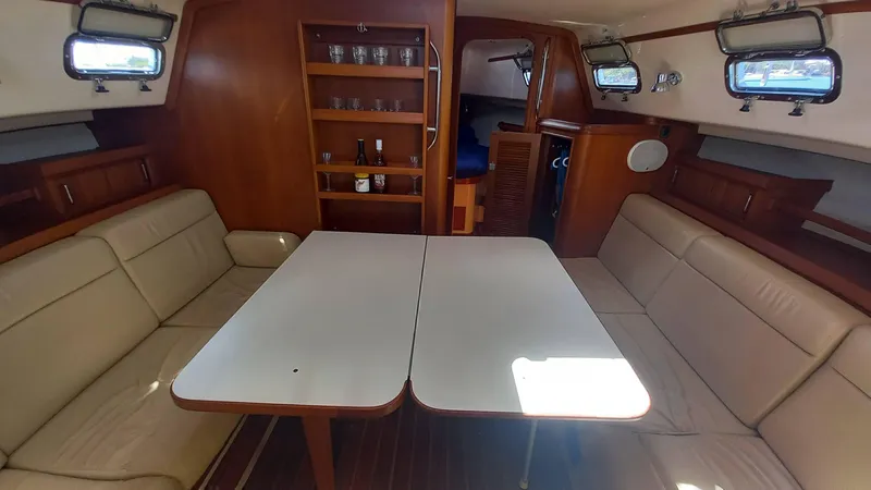 Sunny Girl Yacht Photos Pics Interior of 2004 Island Packet 370 sailboat with beige seating and wooden cabinetry.
