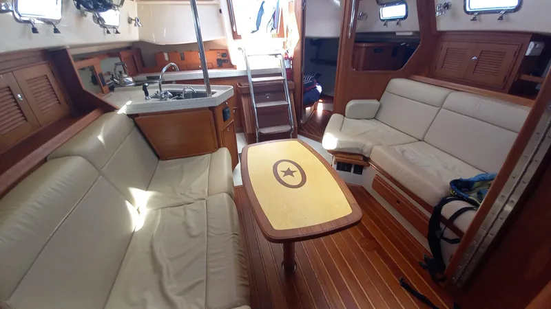 Sunny Girl Yacht Photos Pics Interior of 2004 Island Packet 370 sailboat with cozy seating and wooden finishes.