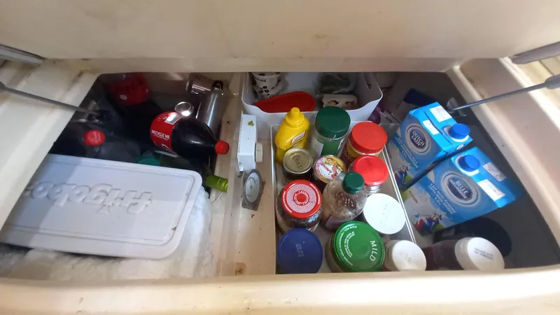 Sunny Girl Yacht Photos Pics Storage compartment on a 2004 Island Packet 370 yacht, filled with various food items and beverages.