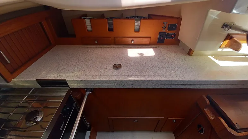 Sunny Girl Yacht Photos Pics 2004 Island Packet 370 yacht kitchen with stove, countertop, and wooden cabinetry.