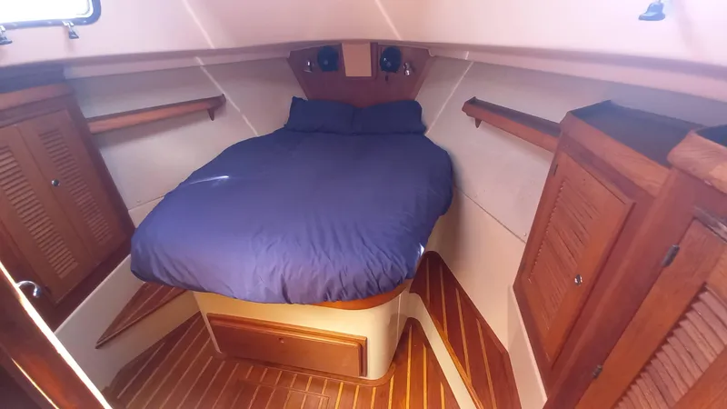 Sunny Girl Yacht Photos Pics Cozy cabin interior of 2004 Island Packet 370 sailboat with wooden accents and blue bedding.