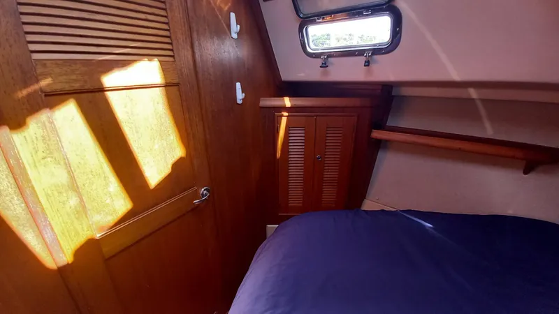 Sunny Girl Yacht Photos Pics Cozy cabin interior of 2004 Island Packet 370 sailboat with wooden accents and natural light.