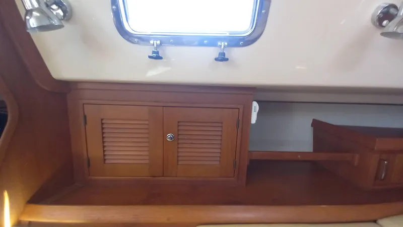 Sunny Girl Yacht Photos Pics Interior of 2004 Island Packet 370 sailboat with wooden cabinets and porthole window.