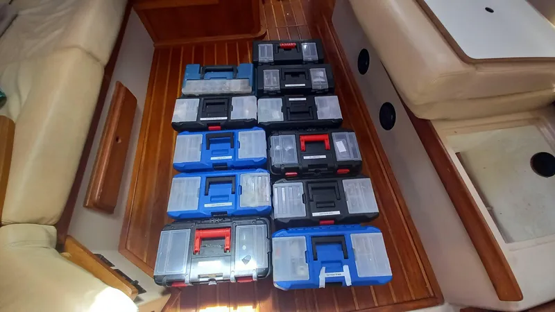 Sunny Girl Yacht Photos Pics Toolboxes arranged on wooden floor inside 2004 Island Packet 370 sailboat cabin.