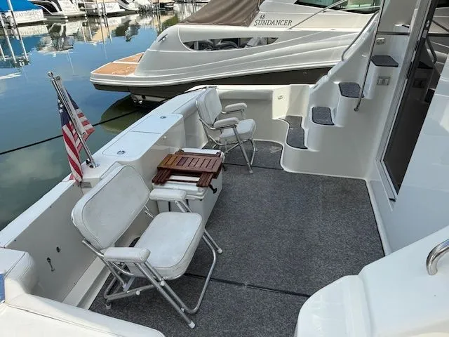  Yacht Photos Pics 2004 Silverton 34 Convertible yacht deck with chairs and American flag in marina.