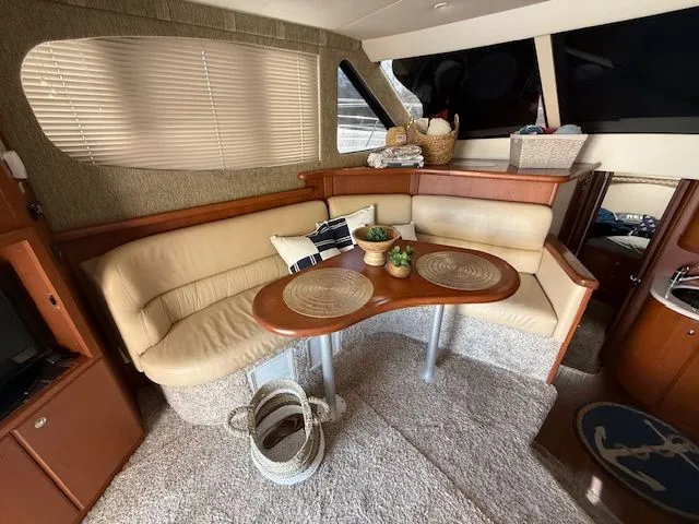  Yacht Photos Pics Interior of 2004 Silverton 34 Convertible yacht with beige seating and wooden table.