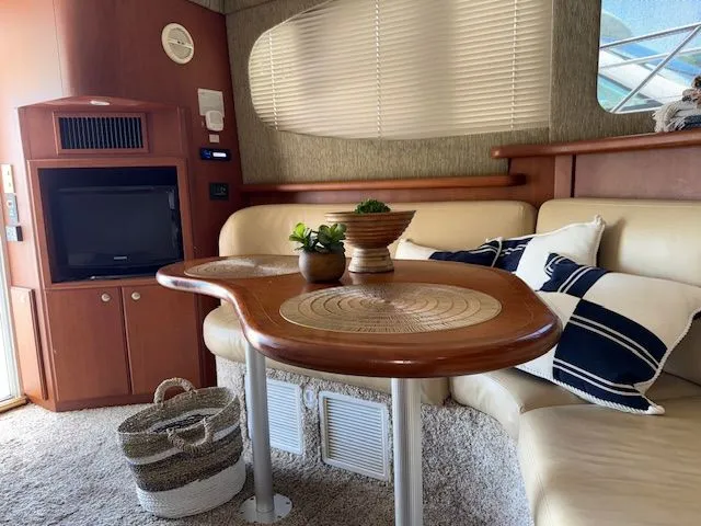  Yacht Photos Pics Interior of 2004 Silverton 34 Convertible yacht with cozy seating and elegant wooden table.