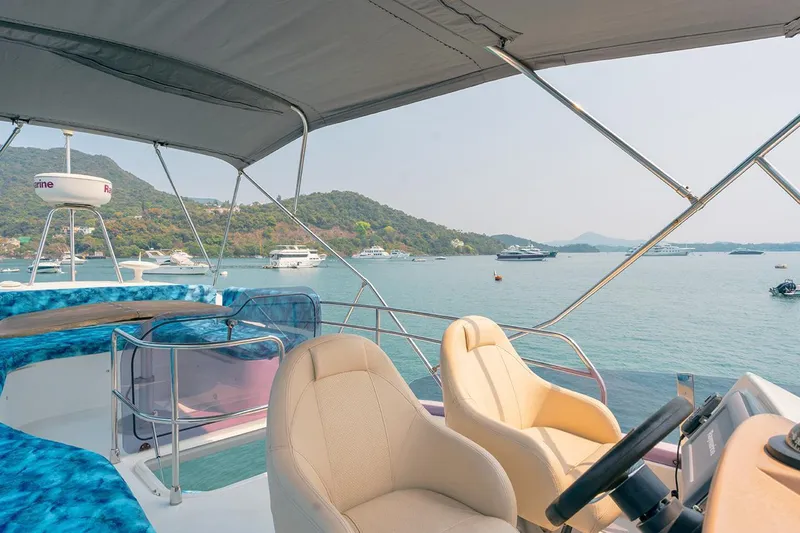  Yacht Photos Pics Flybridge view of 2011 Beneteau Monte Carlo 47 Fly yacht, overlooking serene bay and distant hills.