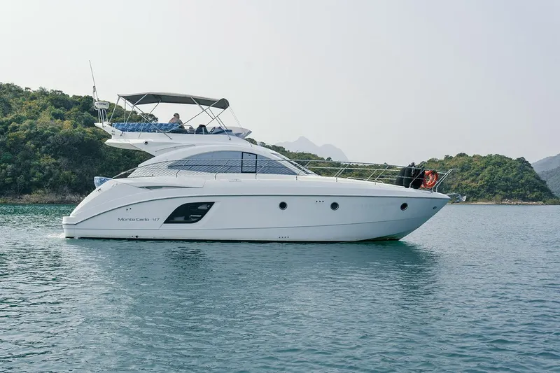  Yacht Photos Pics 2011 Beneteau Monte Carlo 47 Fly yacht on calm water, side view.