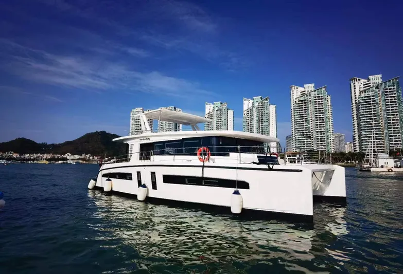  Yacht Photos Pics 2025 Mazarin 55 Catamaran Hybrid Electric EVO II in a scenic marina setting.