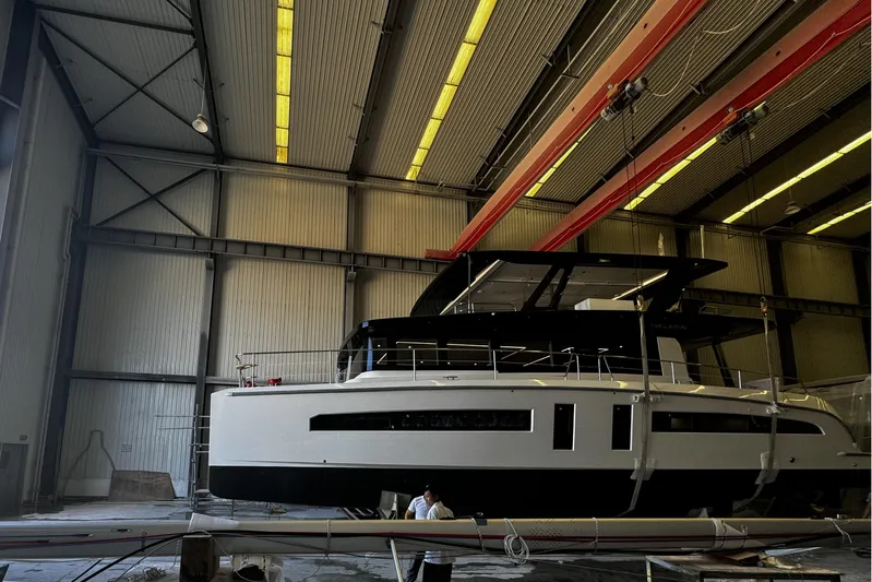  Yacht Photos Pics 2025 Mazarin 55 Catamaran Hybrid Electric EVO II in a spacious indoor facility.