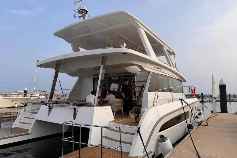  Yacht Photos Pics 2025 Mazarin 55 Catamaran Hybrid Electric EVO II docked at marina with people onboard.