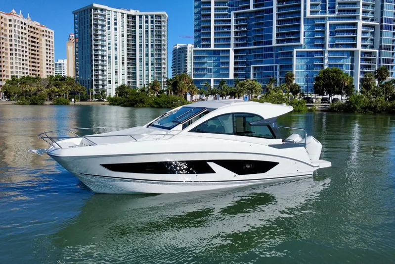  Yacht Photos Pics 2026 Beneteau Flyer 10 yacht cruising near modern city skyline.