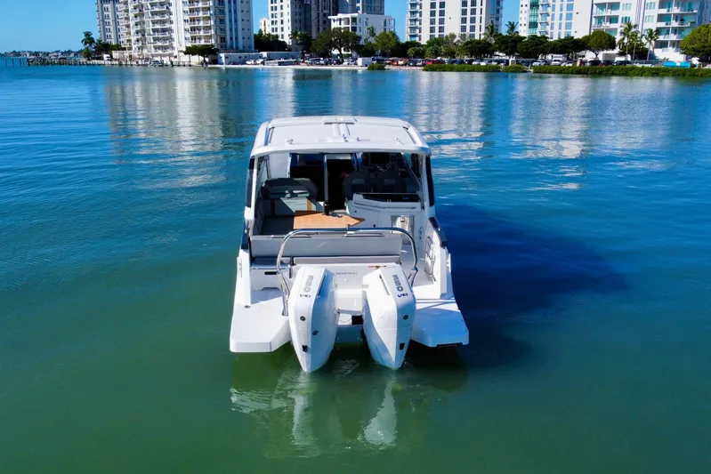  Yacht Photos Pics 2026 Beneteau Flyer 10 boat on calm water with cityscape background.