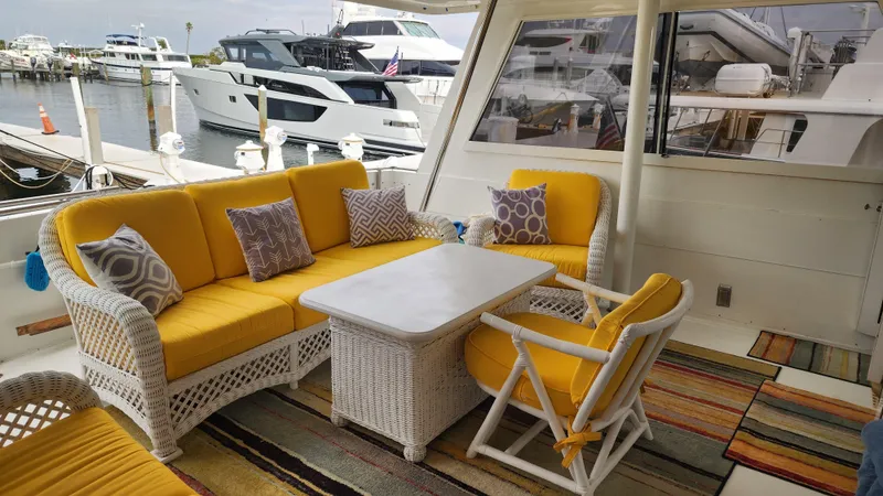 Tropic Jones Yacht Photos Pics Cozy seating area on 1997 Hatteras 52 Cockpit Motor Yacht with yellow cushions and nautical decor.