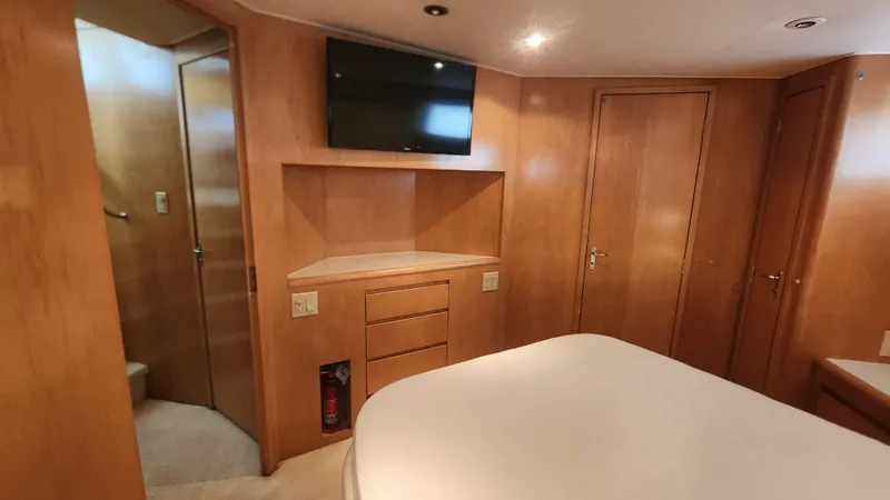 Tropic Jones Yacht Photos Pics 1997 Hatteras 52 Cockpit Motor Yacht interior with wood paneling and mounted TV.