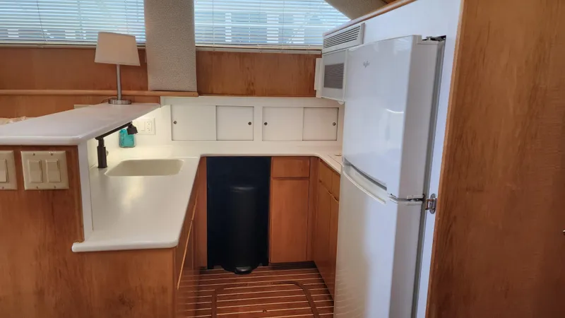 Tropic Jones Yacht Photos Pics 1997 Hatteras 52 Cockpit Motor Yacht kitchen with wood cabinetry and white appliances.