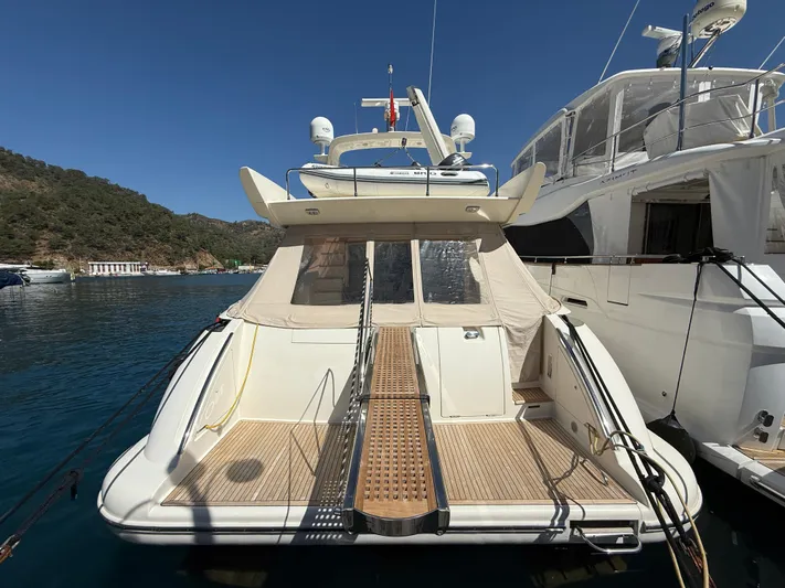 Nvn Yacht Photos Pics 2007 Azimut 62 yacht docked in a scenic marina, featuring a spacious deck and elegant design.