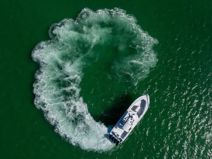  Yacht Photos Pics Aerial view of 2023 Yellowfin 39 Offshore boat making a circular wake in green water.