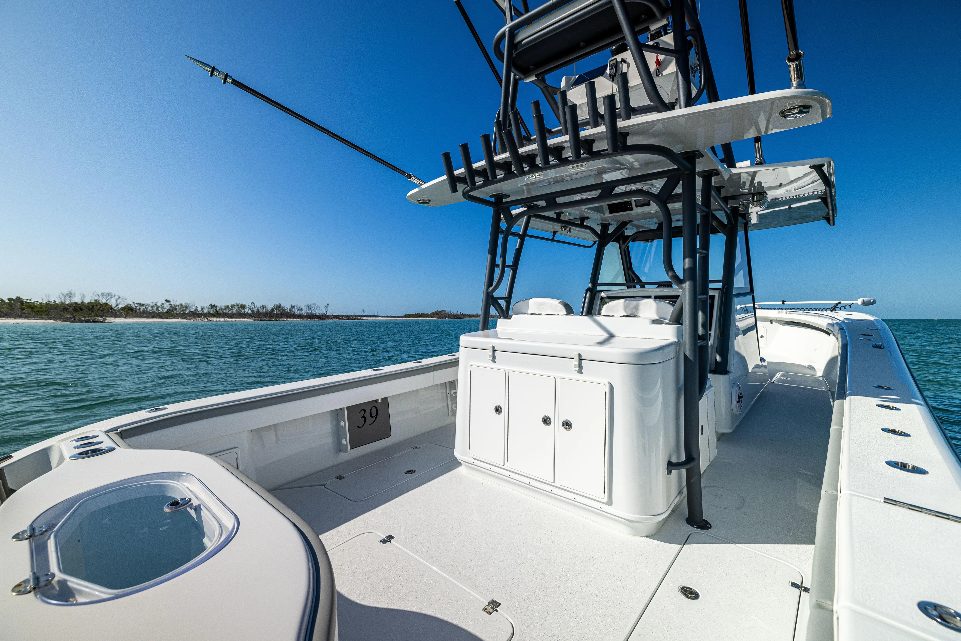  Yacht Photos Pics 2023 Yellowfin 39 Offshore boat on calm sea, featuring spacious deck and fishing equipment.