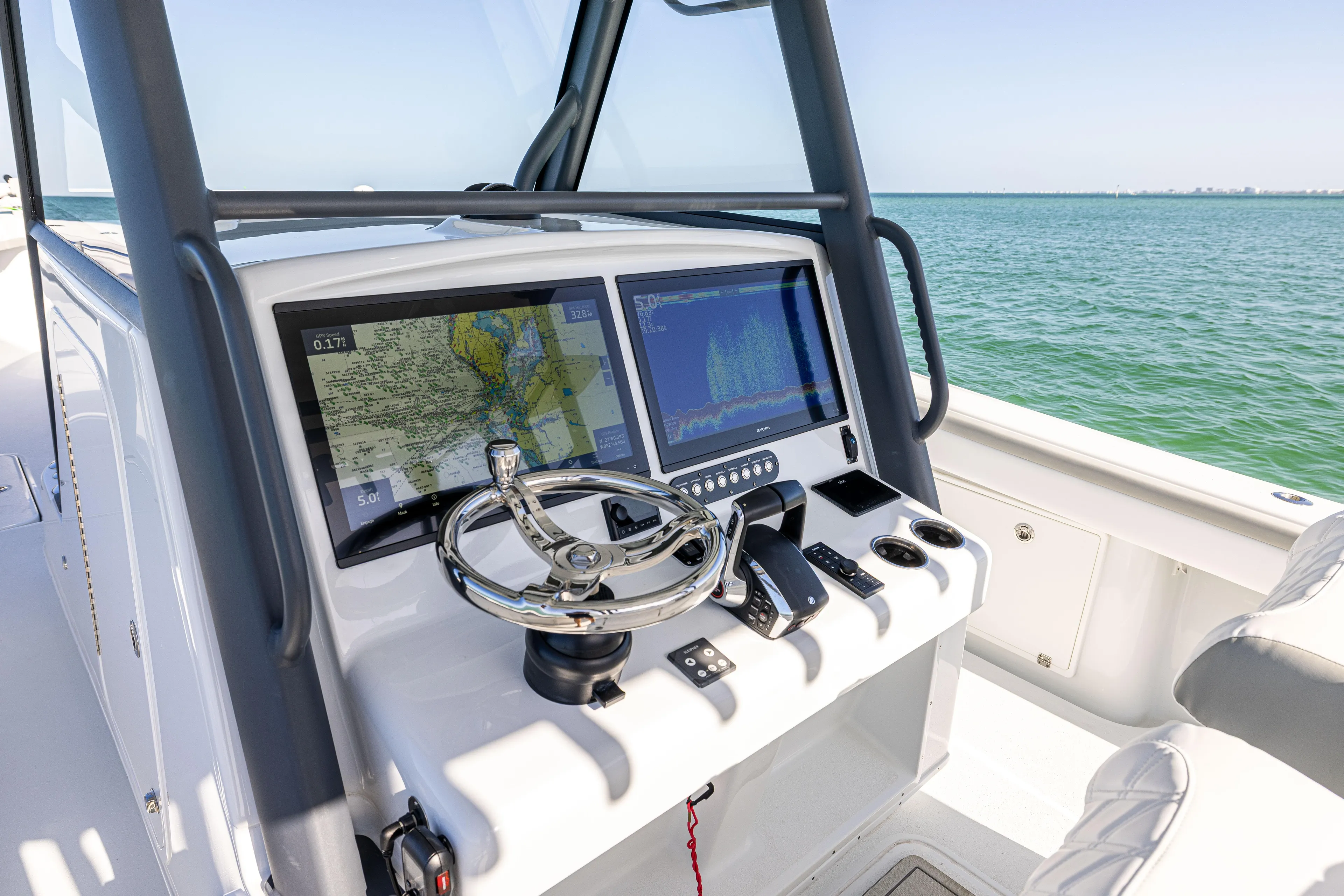  Yacht Photos Pics 2023 Yellowfin 39 Offshore boat dashboard with navigation screens and steering wheel.