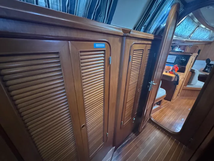 Windsong Yacht Photos Pics Interior of 1989 Taswell 49 yacht with wooden cabinetry and striped curtains.