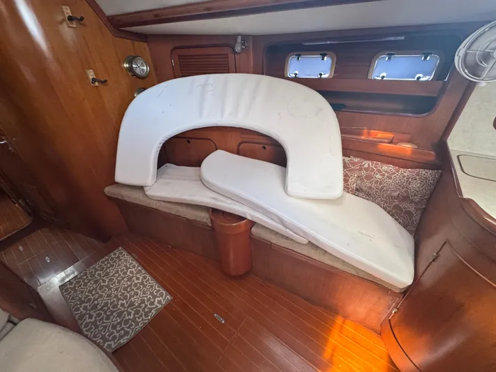 Windsong Yacht Photos Pics 1989 Taswell 49 yacht interior with wooden finish and white cushions.