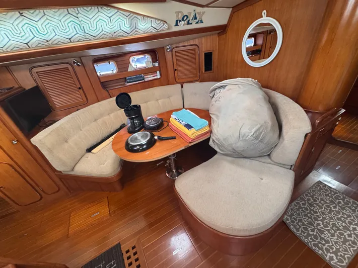 Windsong Yacht Photos Pics Cozy interior of 1989 Taswell 49 yacht with seating, table, and nautical decor.