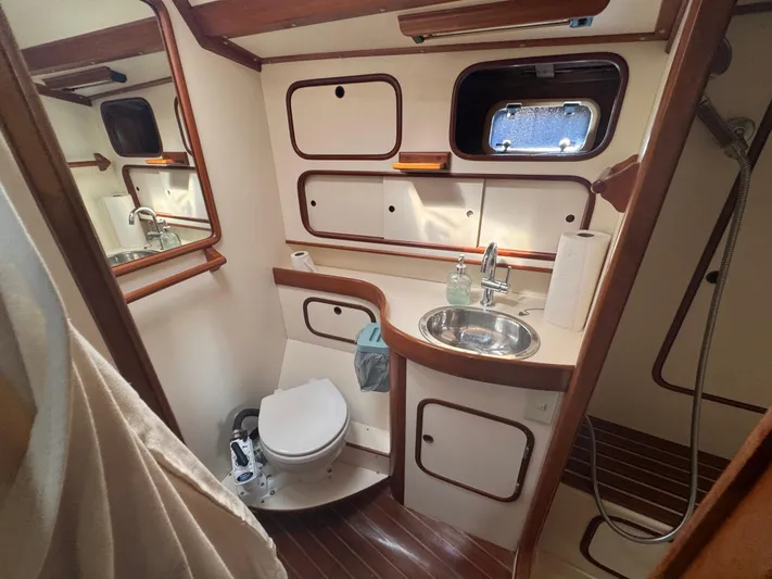 Windsong Yacht Photos Pics 1989 Taswell 49 yacht bathroom with sink, toilet, and wooden accents.