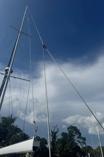 Windsong Yacht Photos Pics Sailboat mast of 1989 Taswell 49 against a cloudy blue sky.