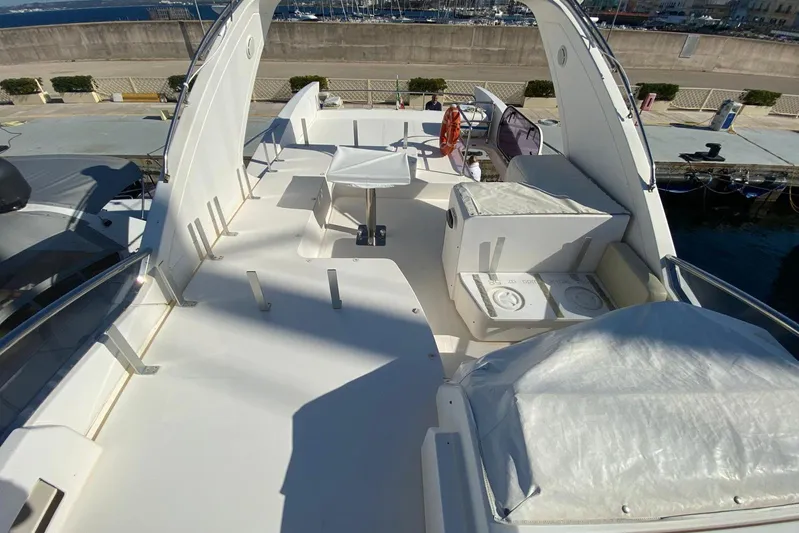  Yacht Photos Pics Flybridge of 2011 Azimut 58 yacht with seating and table, docked at marina.