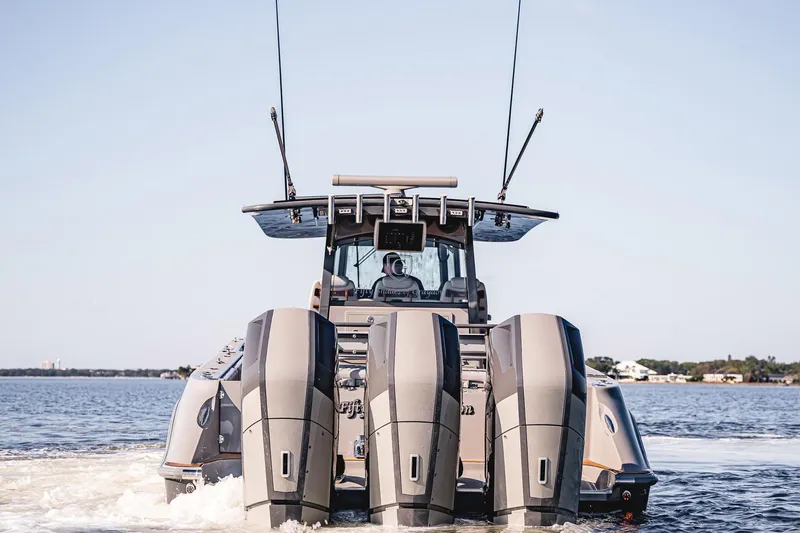 Fifty Shades Of Graydon Yacht Photos Pics 2023 HCB 42 Lujo boat with triple outboard engines cruising on water.