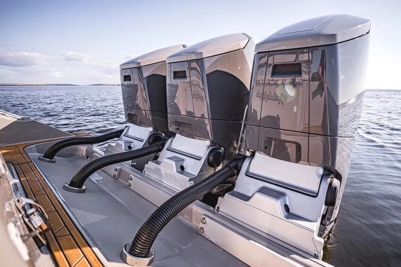 Fifty Shades Of Graydon Yacht Photos Pics Triple outboard engines on 2023 HCB 42 Lujo boat, cruising on open water.