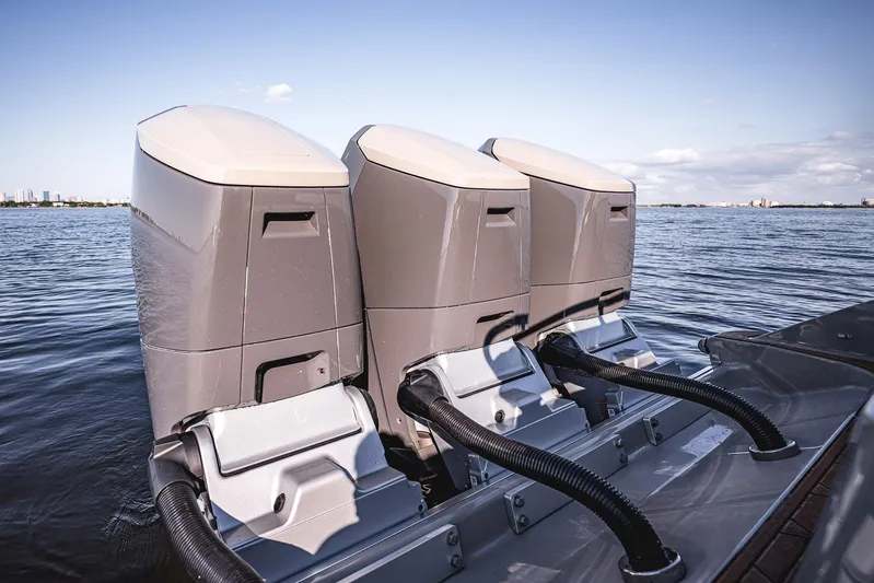 Fifty Shades Of Graydon Yacht Photos Pics Triple outboard engines on a 2023 HCB 42 Lujo boat, cruising on open water.