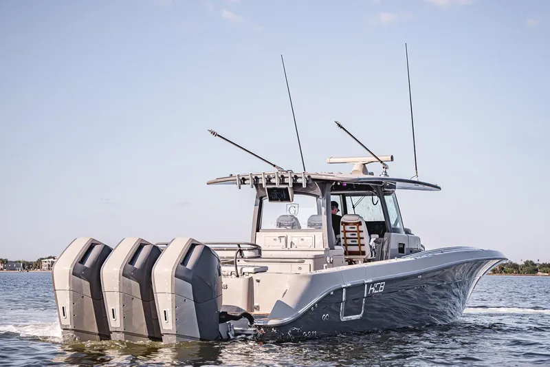 Fifty Shades Of Graydon Yacht Photos Pics 2023 HCB 42 Lujo boat with triple outboard engines cruising on water.