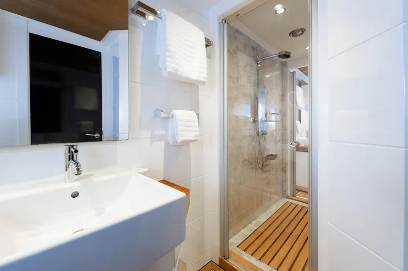 Preference 19 Yacht Photos Pics Modern bathroom with glass shower, wooden floor, and sleek white sink on Tansu Custom yacht.