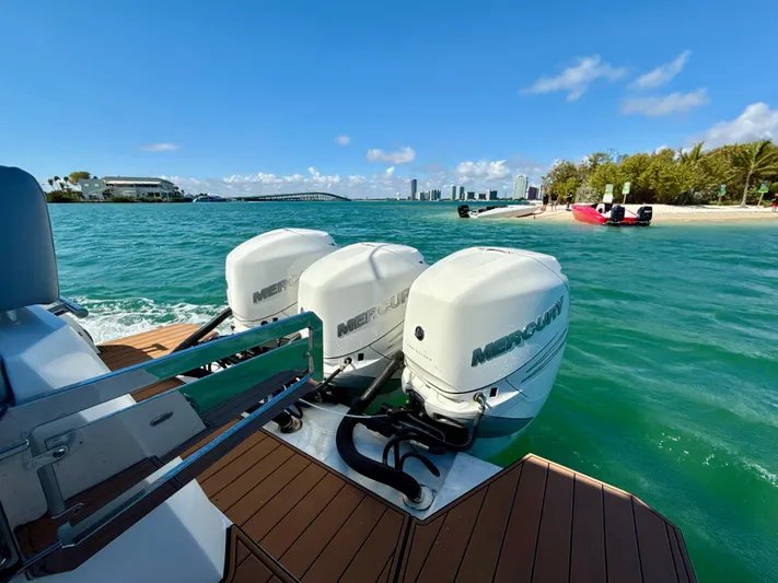 Le Kiki Yacht Photos Pics Azimut 40 Verve 2019 with Mercury engines, cruising near a scenic beach and city skyline.