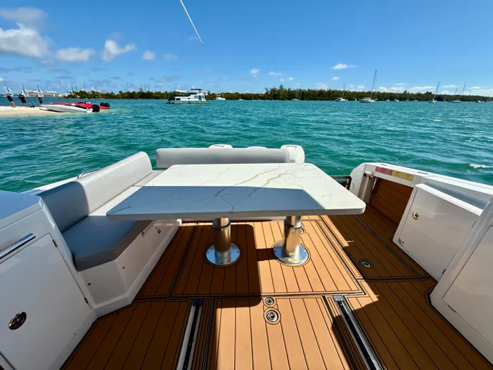 Le Kiki Yacht Photos Pics Azimut 40 Verve 2019 yacht deck with table, overlooking serene blue waters.