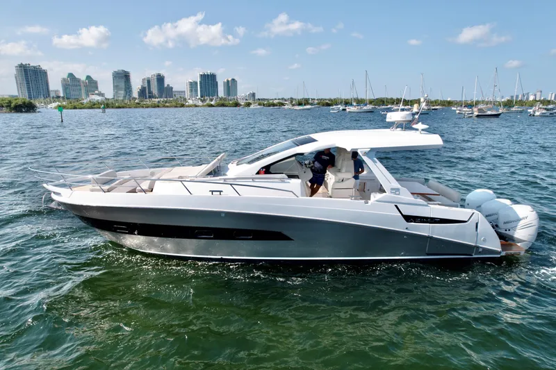 Le Kiki Yacht Photos Pics 2019 Azimut 40 Verve yacht cruising on a sunny day with city skyline backdrop.