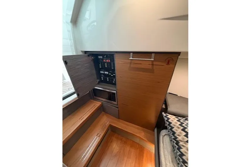  Yacht Photos Pics Interior of 2021 Tiara Sport 38 LS boat, featuring control panel and wooden cabinetry.