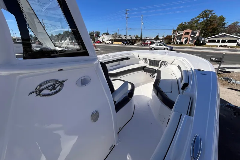  Yacht Photos Pics 2026 Tidewater 256 LXF boat interior with seating and dashboard, parked outdoors.