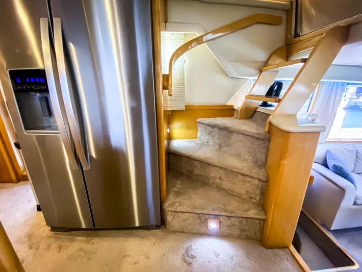Boom Yacht Photos Pics Interior of a 1999 Navigator 5800 yacht with stainless steel fridge and carpeted stairs.
