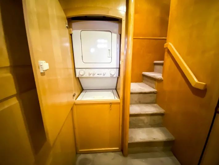 Boom Yacht Photos Pics Laundry area with stacked washer-dryer in 1999 Navigator 5800 yacht interior.