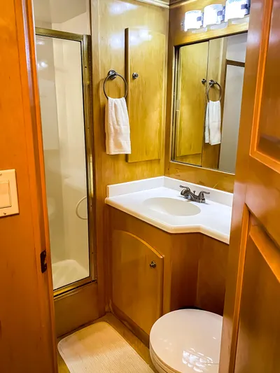 Boom Yacht Photos Pics 1999 Navigator 5800 yacht bathroom with wood cabinetry, shower, and vanity.